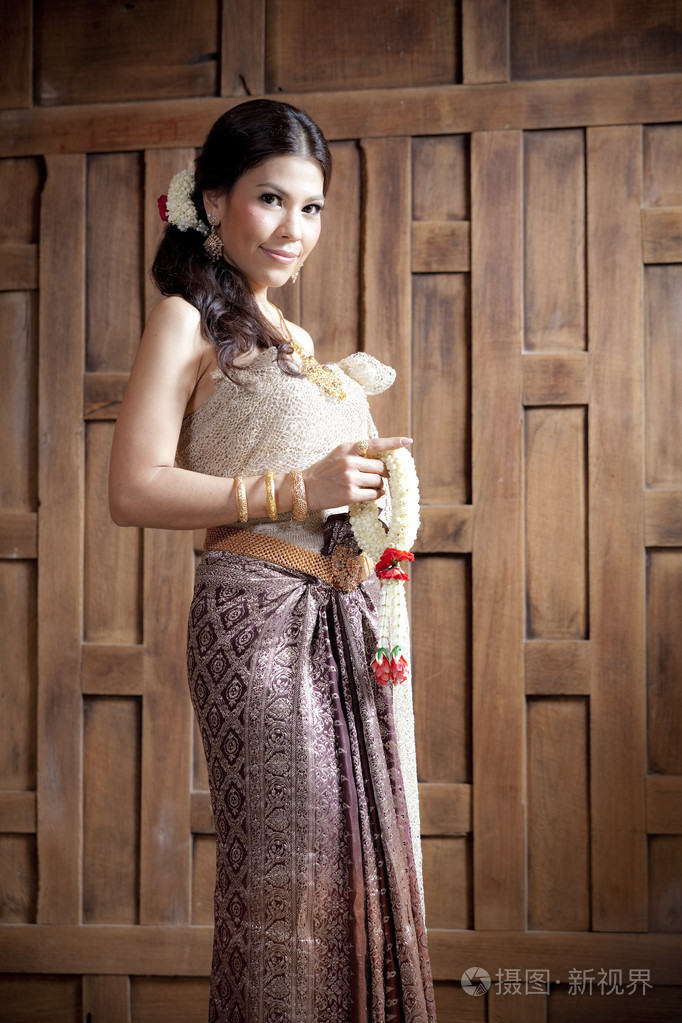 泰国服饰木墙附近的肖像华丽亚洲女人