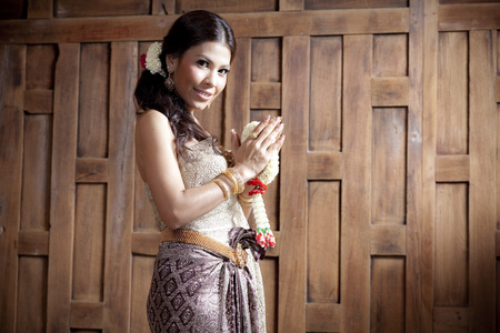 泰国服饰木墙附近的肖像华丽亚洲女人