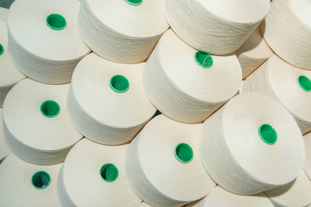 带白色螺纹的线圈。家用纺织品的生产。纯棉白线。织造厂。服装原料