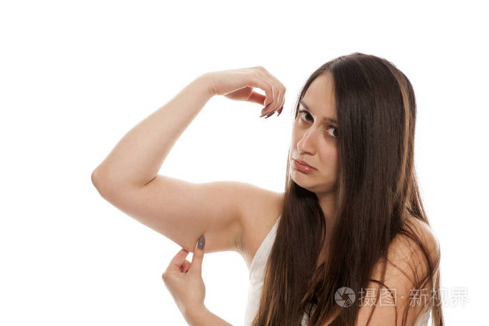 悲伤的年轻女子显示她的松散的手臂皮肤