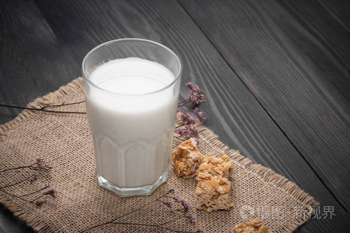 乳制品.一杯牛奶搭配杏仁糖果仿古木制的桌子上