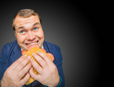 吃美味三明治的滑稽的饥饿的肥胖的人