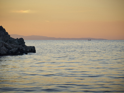 海岩石和遥远的渔民图片