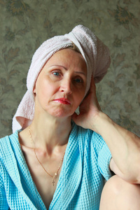 一个女人在用毛巾擦头上的蓝色长袍