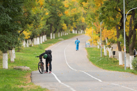 一个人在马路边修理自行车照片
