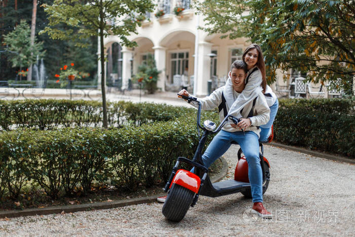 快乐美丽的情侣在休闲服装骑在电动自行车