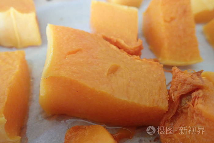 一个橙色的南瓜切成碎片的细节在厨房