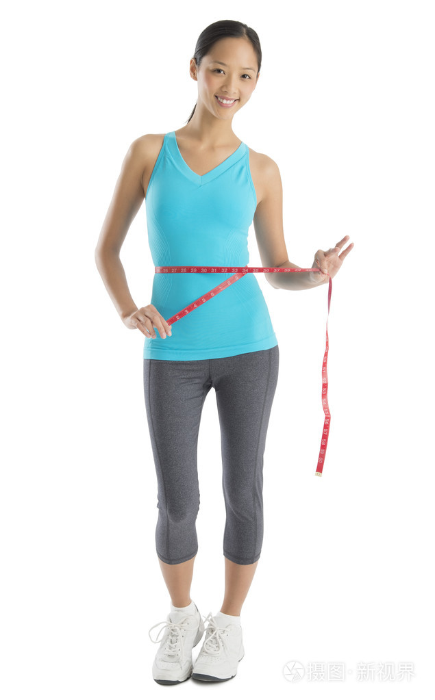 测量她的腰围的幸福女人肖像