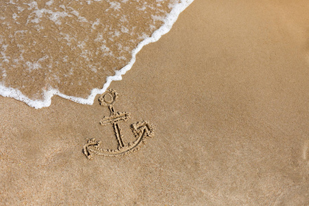 在沙滩上绘制的锚。暑假背景