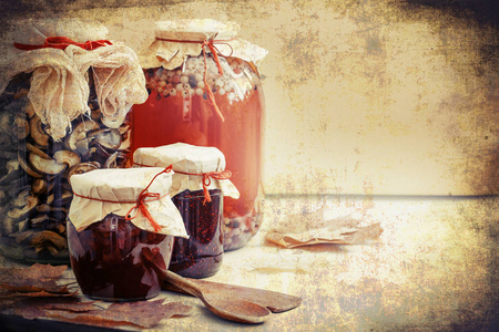 木桌上的时令浆果果酱蜜饯和蘑菇罐头