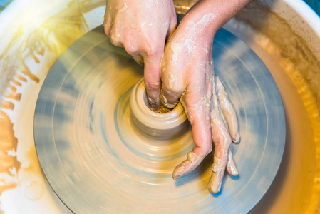 妇女手的陶工创造一个陶罐
