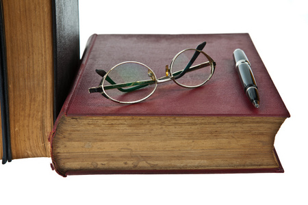 旧书籍用眼镜和孤立在白色背景上的钢笔