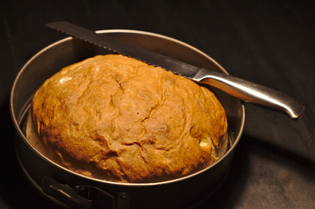 新鲜烘焙的自制面包在一个黑色的背景圆烘烤盘