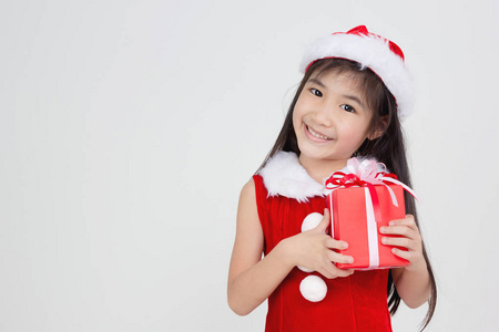 红色圣诞老人礼服快乐的小亚洲女孩的画像