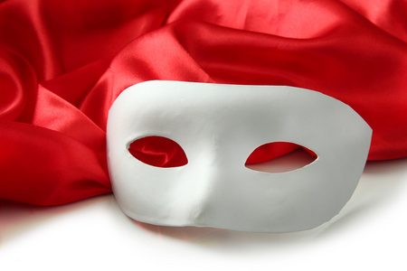白色的面具和红色的丝绸面料，孤立在白色