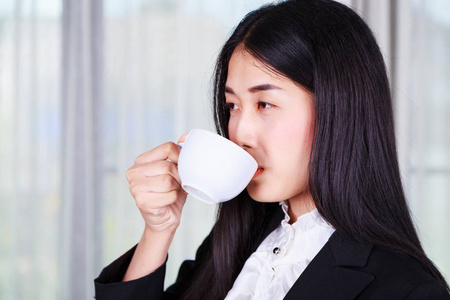商务妇女在适合饮用的咖啡或茶杯