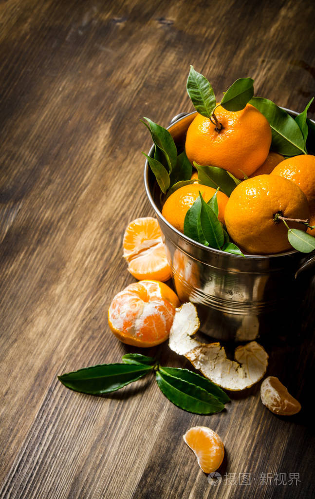 在叶一桶新鲜橘子