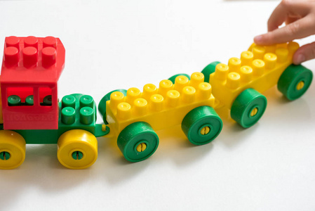 玩具颜色设计师, 火车。孩子玩, 并建立了立方体。孩子的手。在白色背景上
