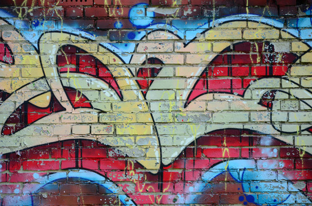 涂鸦画碎片。在街头艺术文化的风格上装饰着漆渍的旧墙。彩色背景纹理在温暖的色调