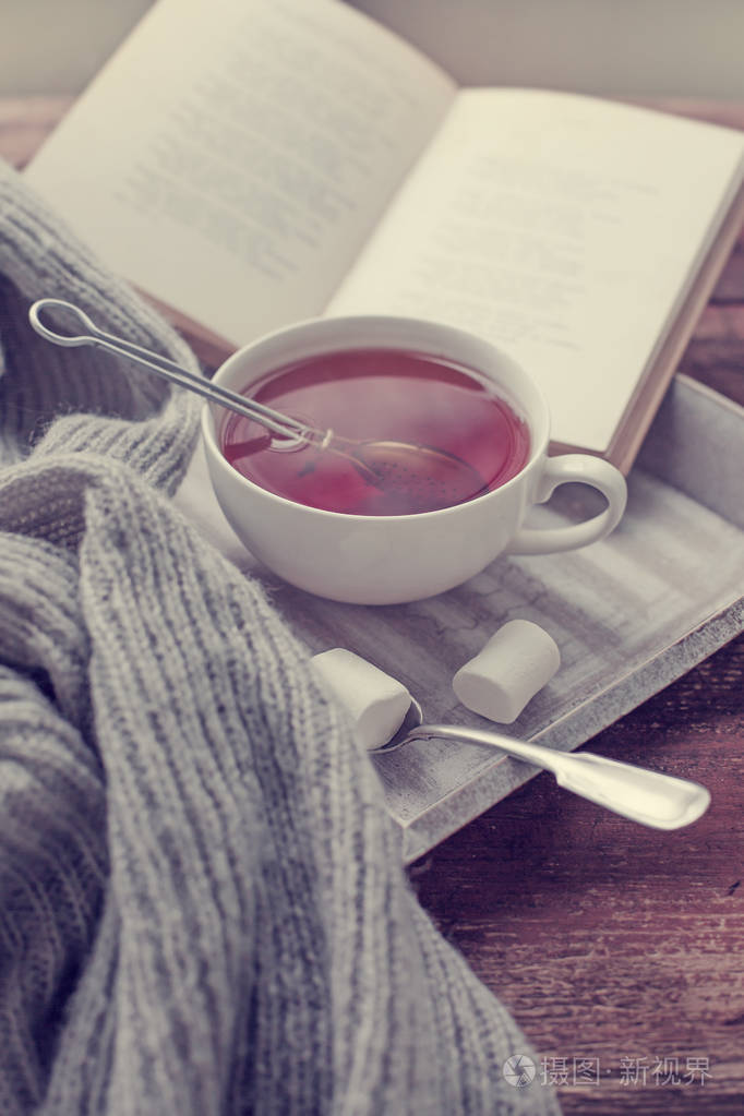 一杯热茶和木制表面的书