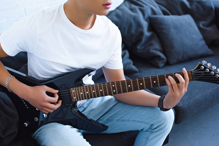 在家里玩电吉他的吉他手的裁剪图像