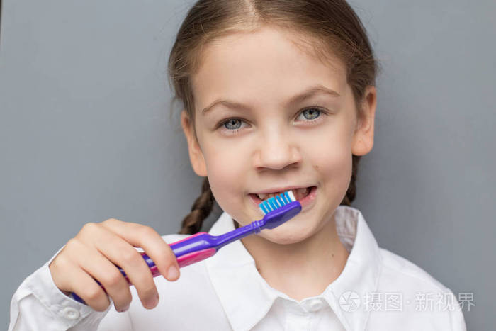 可爱的小女孩刷牙她的牙齿.无牙学龄儿童.牙科护理