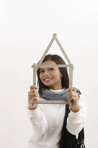 马来女人拿着 folderable 的尺子形成房子形状