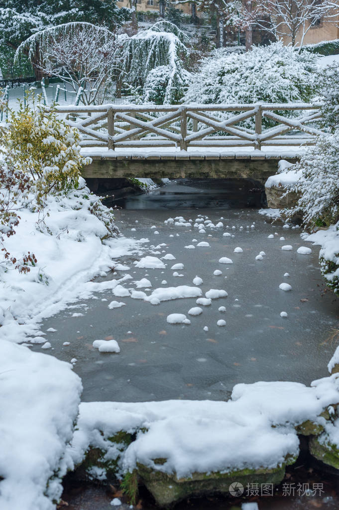 冬季冰雪下的冰冻溪流和小桥