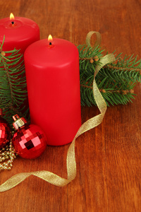 两支蜡烛和圣诞装饰品，木制背景上