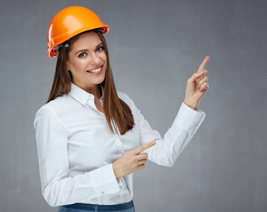 保护头盔的妇女建设者在复制空间指向手指