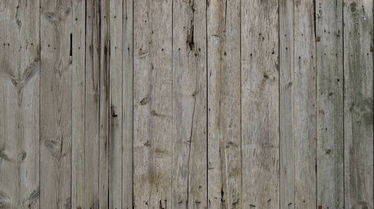 风化的木墙的纹理。老年的木板搭起的垂直平面板围栏