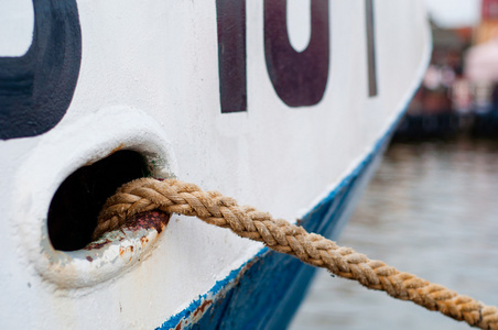 白色船体与系泊绳缆船起锚照片