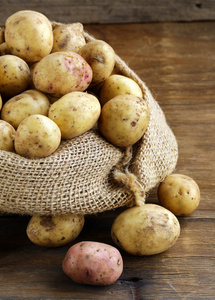 新鲜有机土豆上一个木制的背景，乡村风格