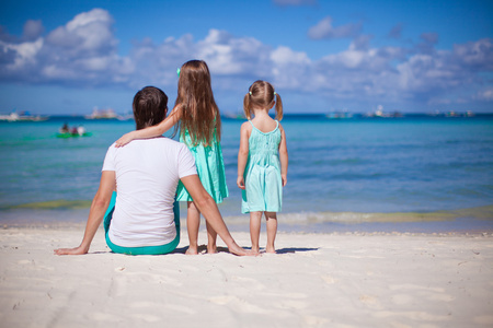 热带海滩度假回来很高兴父亲与他的两个女儿的视图