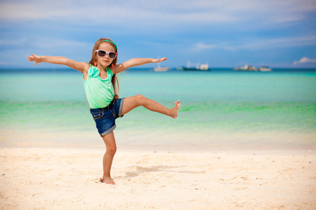 漂亮的小女孩在异国风情的海滩上很开心