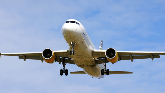 定期天巴塞罗那的天空中飞行的商业客机照片