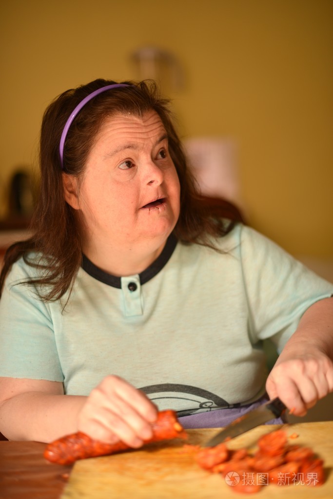 有吸引力的唐氏综合征女人在厨房里做饭