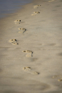 细节拍摄与男子脚印在沙滩上的沙子