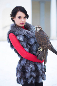 羽毛背心女人抱着一只猎鹰照片