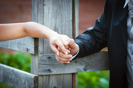 年轻已婚夫妇手挽手在婚礼上照片