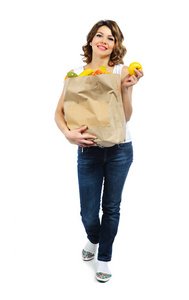 年轻女孩在纸袋上白色隔离的水果