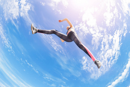 女子运动员在空中跳跃或奔跑时保持静止的低角度视角