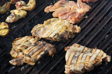 大腿和鸡胸脯煮熟在巨型烤肉在雀鳝