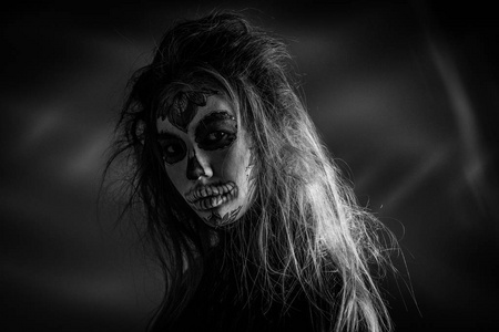 一个女孩的肖像在万圣节的化妆死男人.黑白照片照片