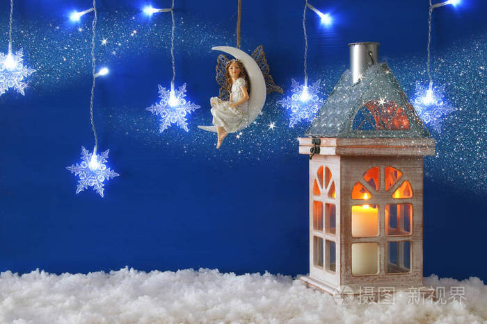 木老房子与蜡烛和仙女在月亮在雪和蓝色背景