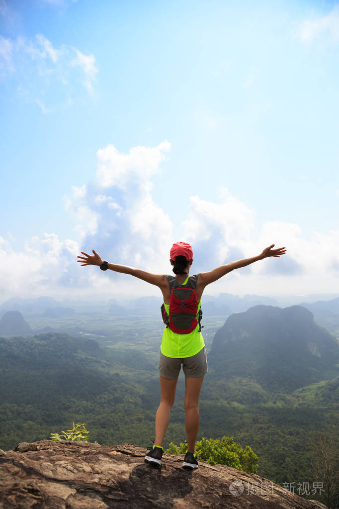 成功的女性张开双臂, 在山顶上美丽的风景