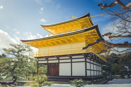 美丽的冬季金阁寺寺金色阁的白雪飘落和蓝天背景在京都, 日本