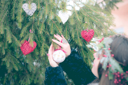美丽的年轻女孩装饰圣诞树在新的岁月内部
