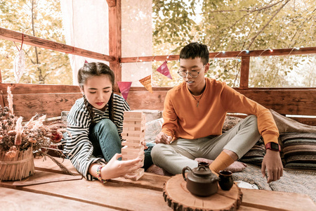 严重的黑发女孩玩叠叠乐与她的伴侣