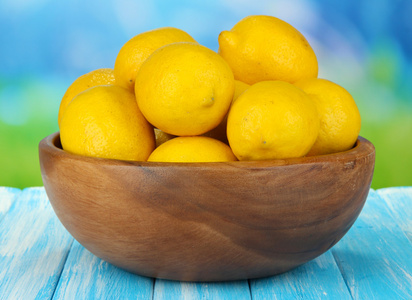 在明亮的背景上桌上的碗里成熟柠檬